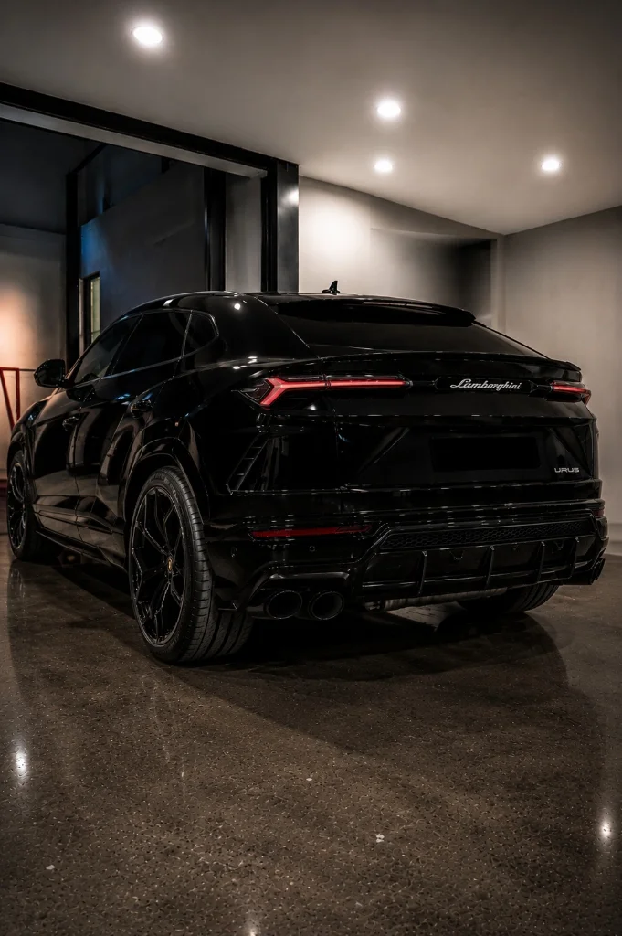 Black Lamborghini Urus rear three-quarter view inside the workshop