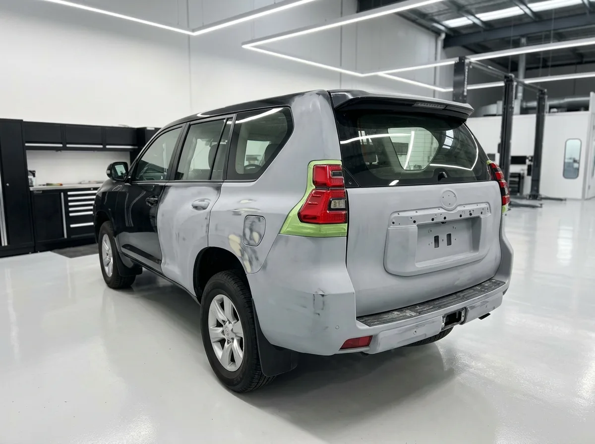 Black Toyota Prado in bare primer mid-repair inside the Stow Smash Repairs workshop